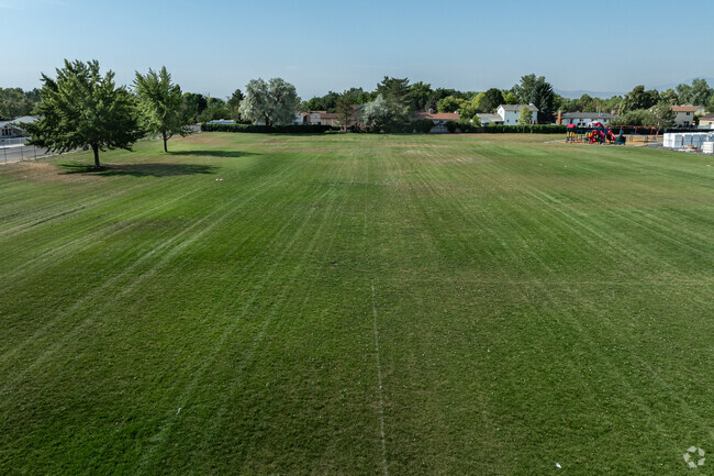 Oquirrh Elementary School has a long field peppered with trees.