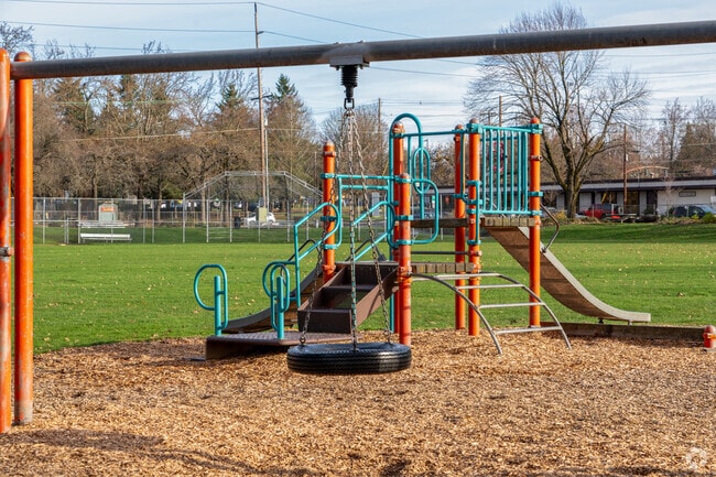 Playground structure showing baseball field in the background.