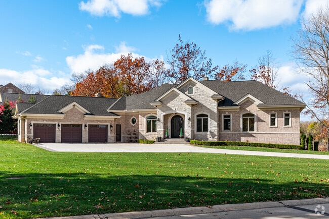 Brick Ranch style home with a tidy lawn in Orchard Lake Village.