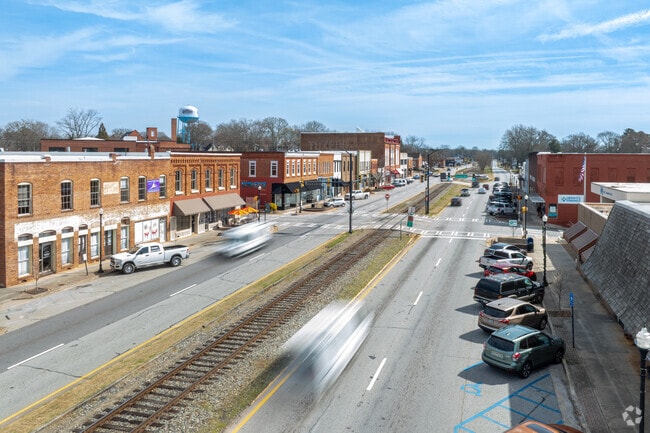 Downtown Commerce is a vibrant area, characterized by its original train track that weaves through the heart of the district, flanked by charming historic brick buildings that echo the rich heritage of the past.