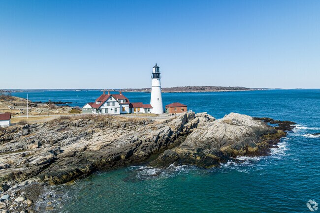 Fort Williams Park prominent Portland Head Lighthouse lights up the Loveitts Field shore.