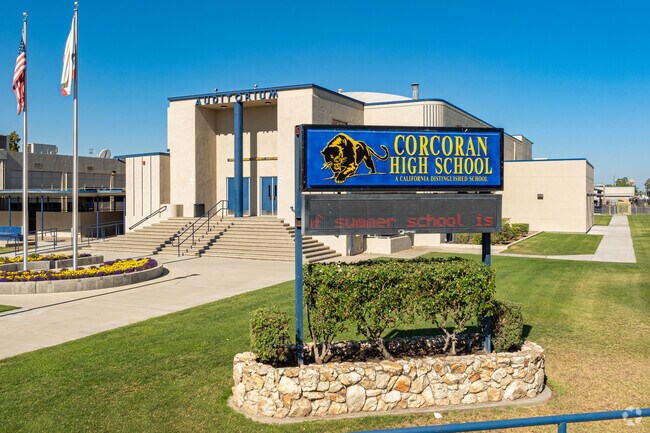 A large lighted marquee at the entrance to Corcoran High School informs parents of events.