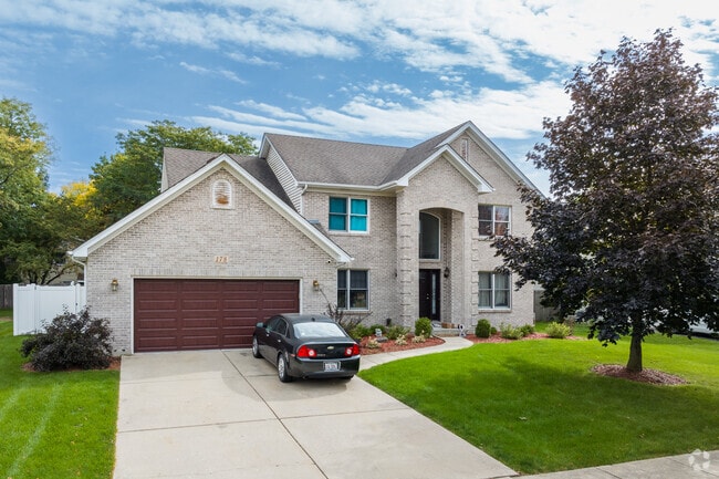 This brick home built in Indian Chase Meadows sits smartly in contrast to a Red Maple Tree.