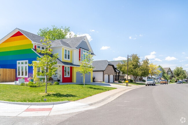 A colorful home pops among a row of sleek modern houses in Signal Creek, adding vibrant charm and personality to this stylish, close-knit neighborhood.