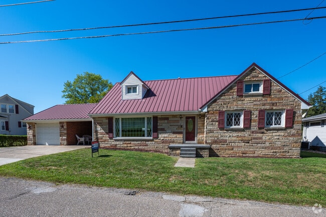 A stone ranch home with a metal roof stands out along the streets of Bellaire.