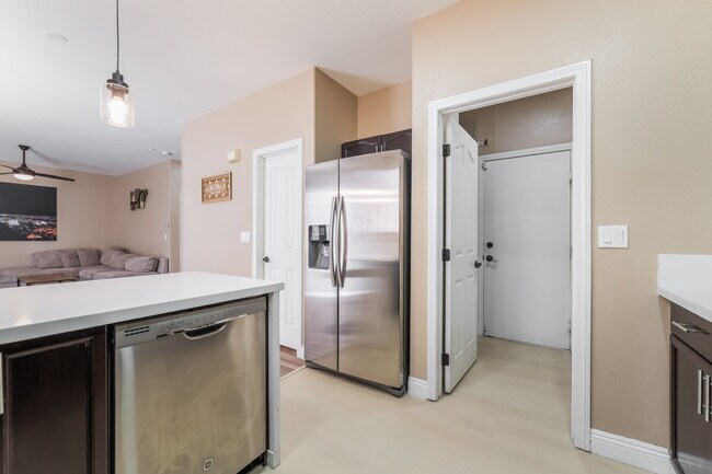 Kitchen featuring light countertops, appliances with stainless steel finishes, dark brown cabinets,