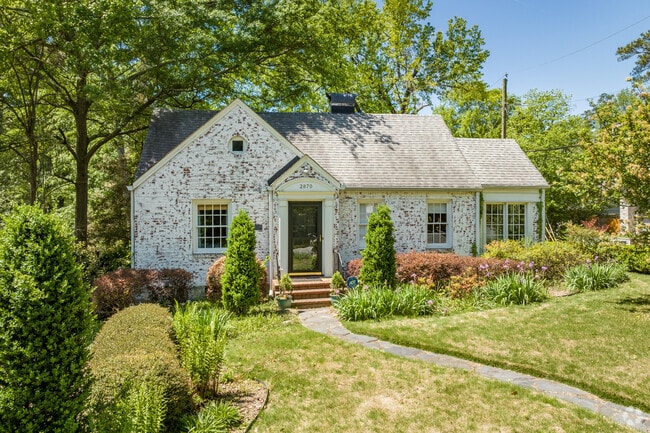 An old tudor style home with meticulous landscaping in the Garden Hills Neighborhood.