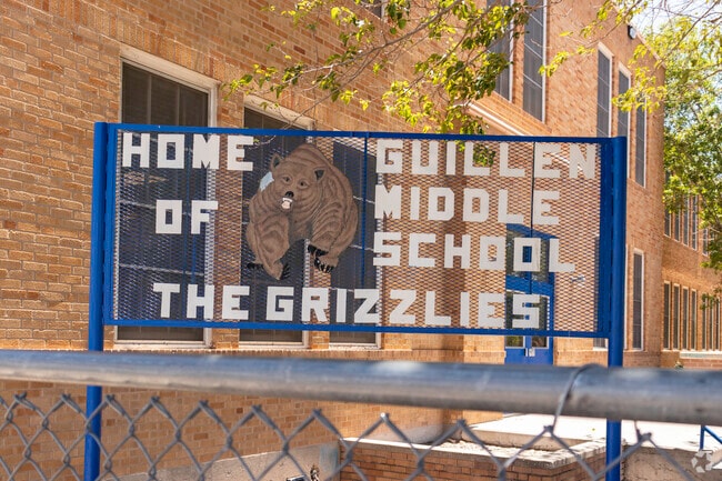 Fence signage shows Guillen Middle School's mascot, the Grizzly.