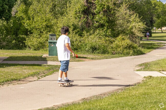 Walkers, bikers, and skateboarders use the paved Shingle Creek Regional Trail around the Palmer Lake Environmental Nature Area.
