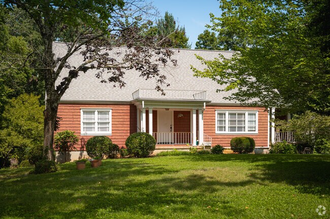 A brick cottage sits on a wooded lot in Stuart Heights-Rivermont.