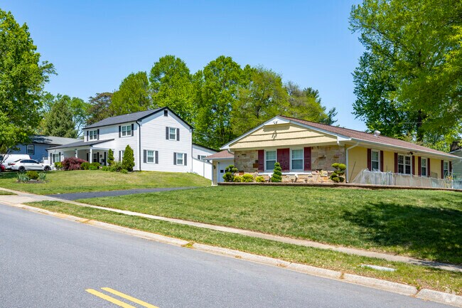 A yellow ranch and a white colonial revival sit on a gentle slope in Whitehall.