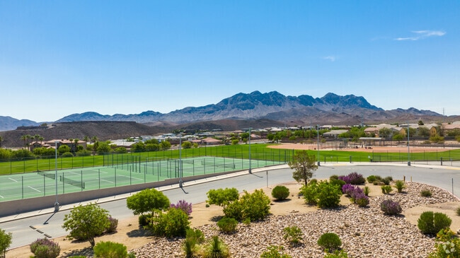 Mid level aerial shot of the tennis courts and sports/baseball field as seen from the parking lot.