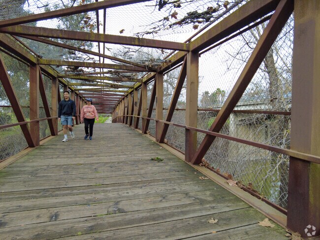 Graceful strides unite nature lovers on Hellyer County Park's scenic bridge.