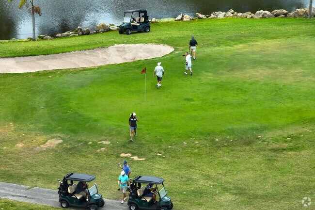 Golfers enjoying a game at The Lake Worth Beach Golf Course beside Mango Groves.