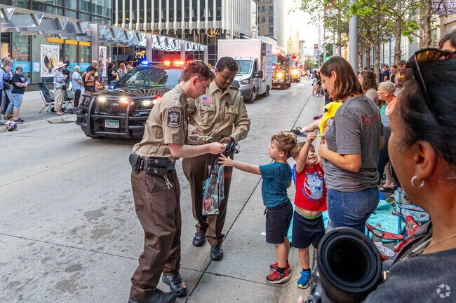 The Hennepin County Explorers hand out sheriff badge stickers to the kids along the parade route