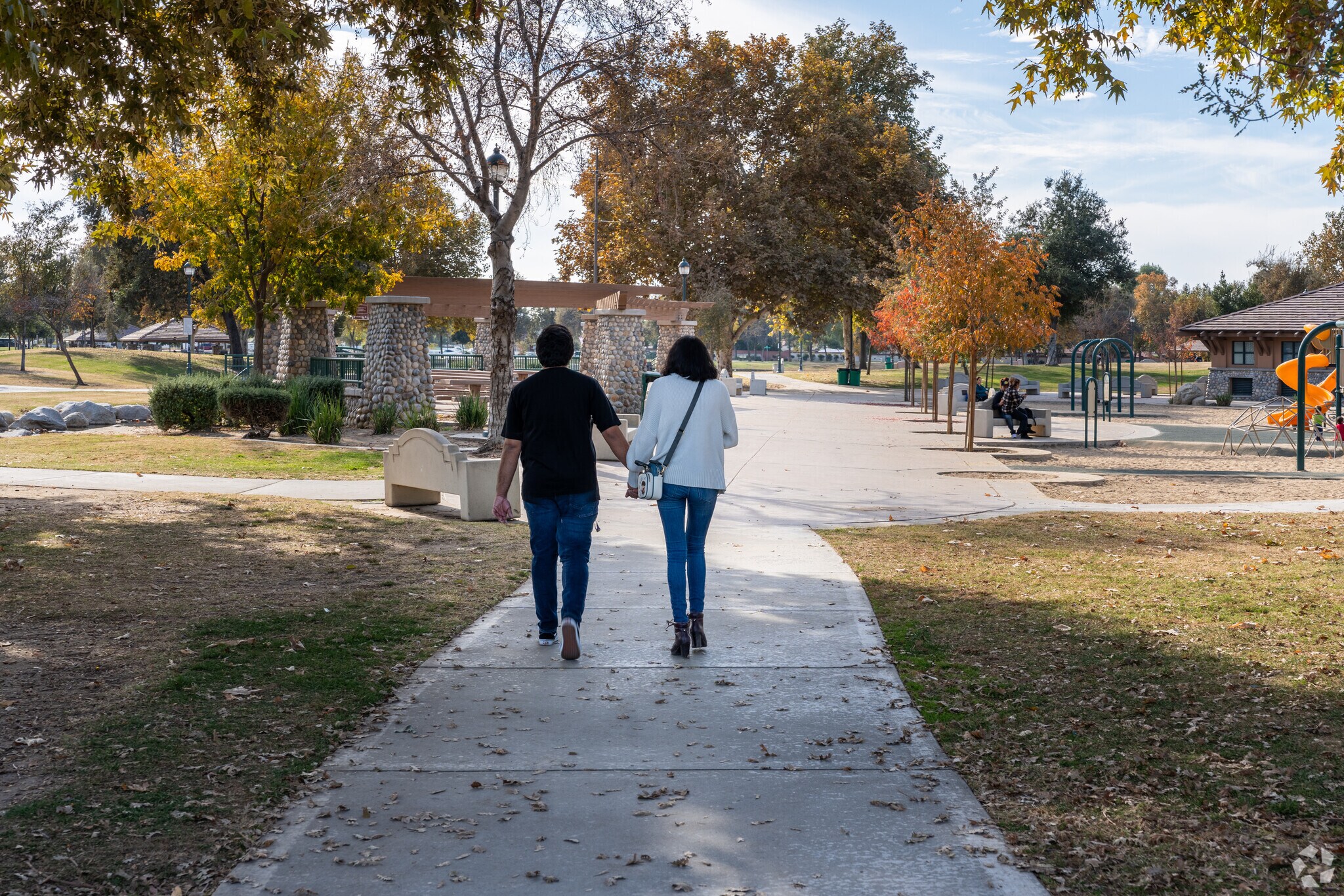 A couple enjoys a leisure walk at the Park at Riverwalk near River Oaks.