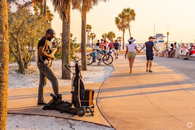 Stroll past performers on the pier at sunset.