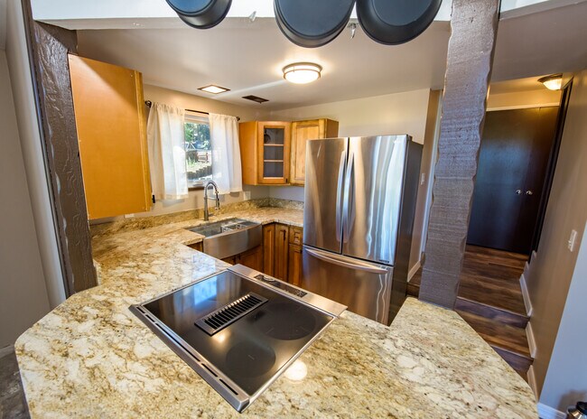 Kitchen with stainless steel electric range, barn style sink and refrigerator