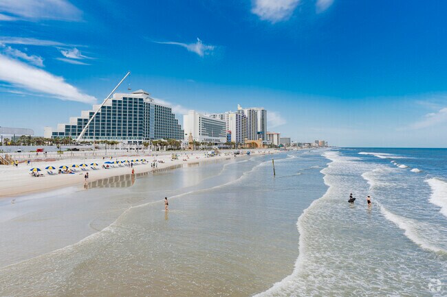 Daytona Beach Shores has small waves with blue water.