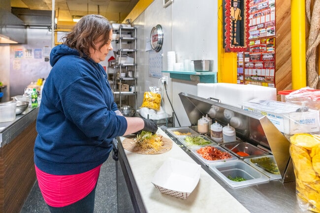 A worker prepares a burrito at Taco Beyondo, a Mexican restaurant near Deering.