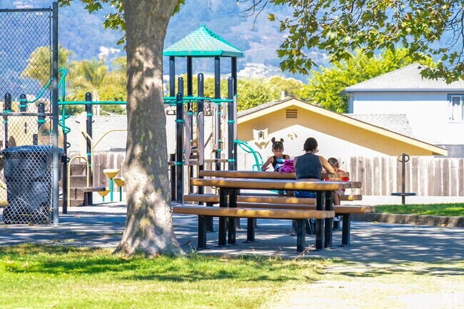 A family sitting down enjoying the summer breeze in Mesa Village Park.