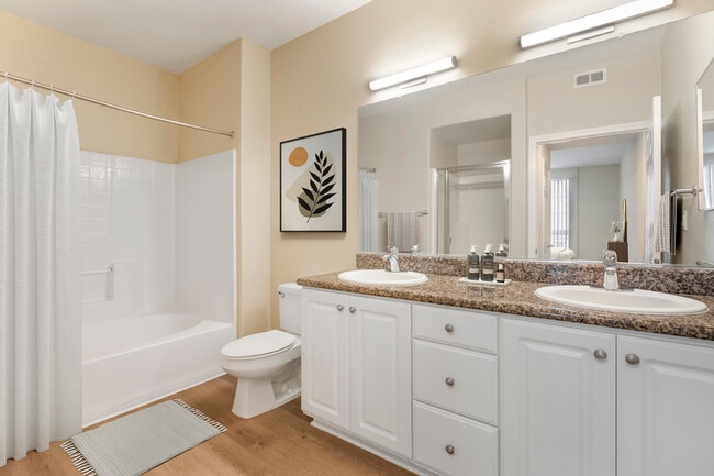 Renovated Package I bath with beige speckled granite countertop, white cabinetry, and hard surface flooring