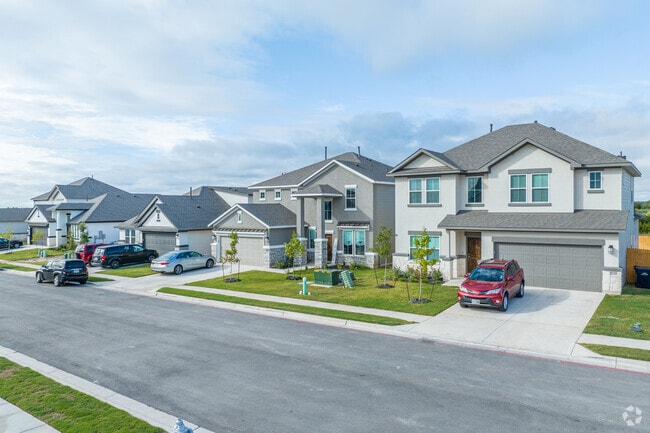 Diverse homes in Liberty Hill feature various stone facades, showcasing architectural variety.
