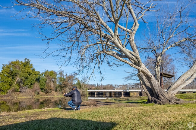A young man takes a photo of the reflective water at Orange Lions Park.