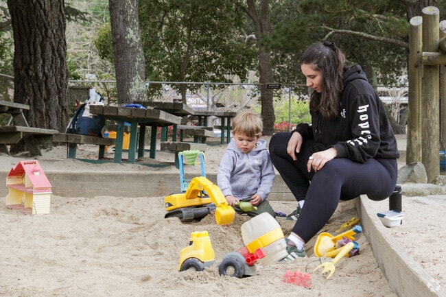 A child plays joyfully in the sandpits at Orinda Community Park.