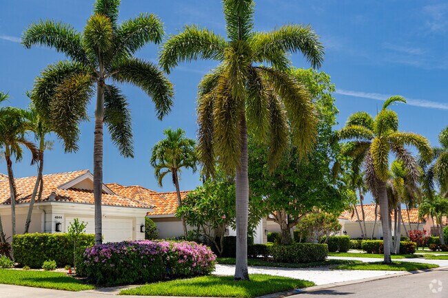 Homes in Village Walk of Naples feature well manicured lawns and tropical landscaping.