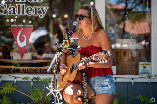 Local musicians play during the Christmas in July Market on nearby Canal Street.