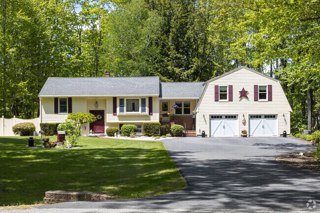 A split‑level with attached garage sits amid trees in North Arundel.