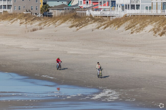 Oak Island residents go for a fun bike ride on the beach with a nice ocean breeze.