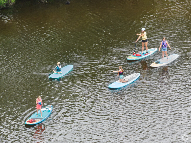 A family paddle boards down the river in Brookhaven.