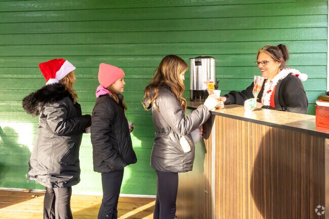 Girls line up for hot chocolate, warming up as they enjoy the festive atmosphere.