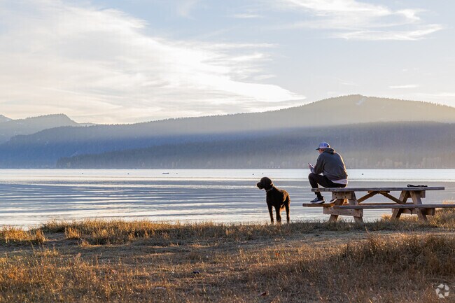 A man enjoys the setting sun with his best friend at Lake Forest Beach.