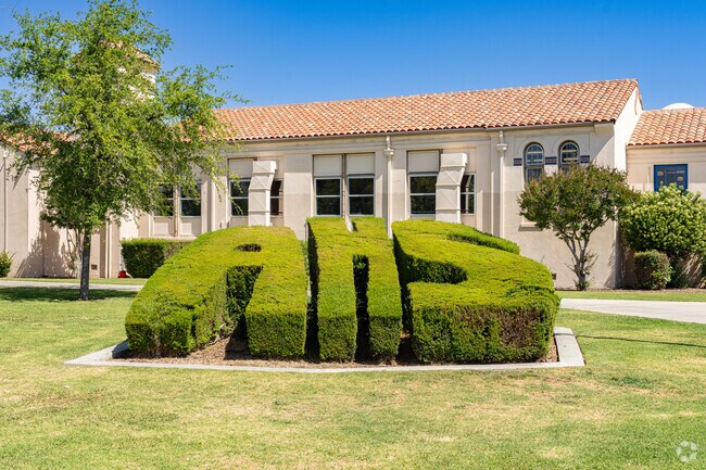 A large hedge at the entrance to Avenal High School is carefully trimmed.