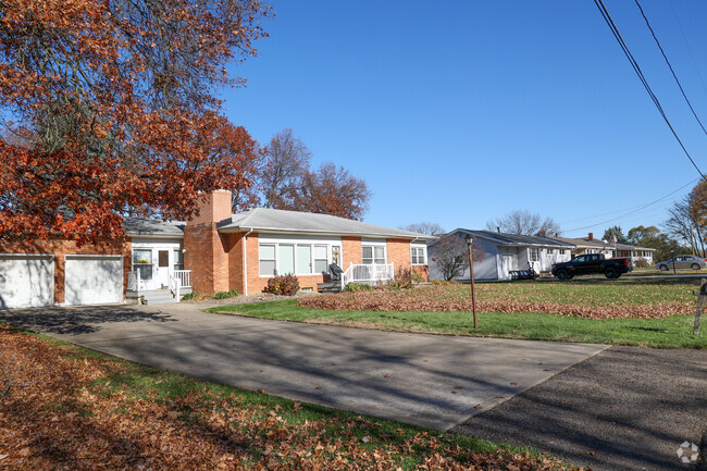 A Brick Ranch style home with colorful leaves on the lawn, in Sippo Lake.