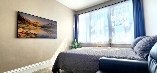 Primary Bedroom -Enjoy a 55” Samsung Frame TV and ample natural light through the oversized windows.