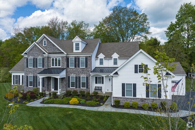 A large Colonial home in Edgmont with dormer windows and stone features.