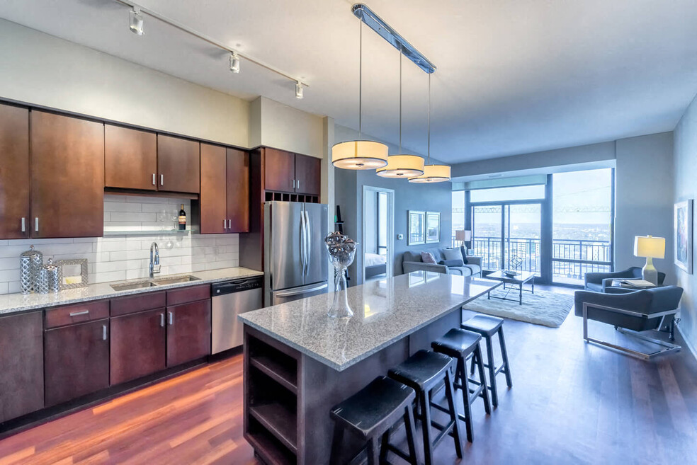 Nic on 5th Apartments in Minneapolis, Minnesota- Large common room with wooden cabinets, floors and granite countertops