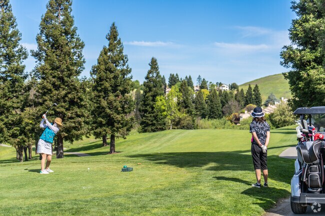 A foursome of ladies tee off at Canyon Lakes Golf Course.