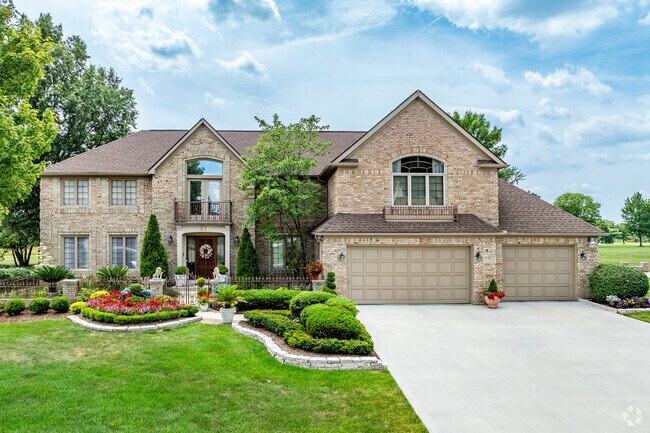 A traditional two-story home in Woods at Josephinum features beautiful landscaping.