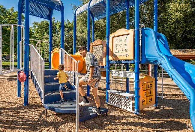 A dad and son enjoy a cool morning on the playground in Northrup’s Swanston Park.