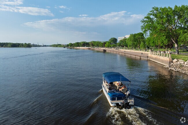 Boaters take a slow pass by Riverside Park on the Mississippi River.