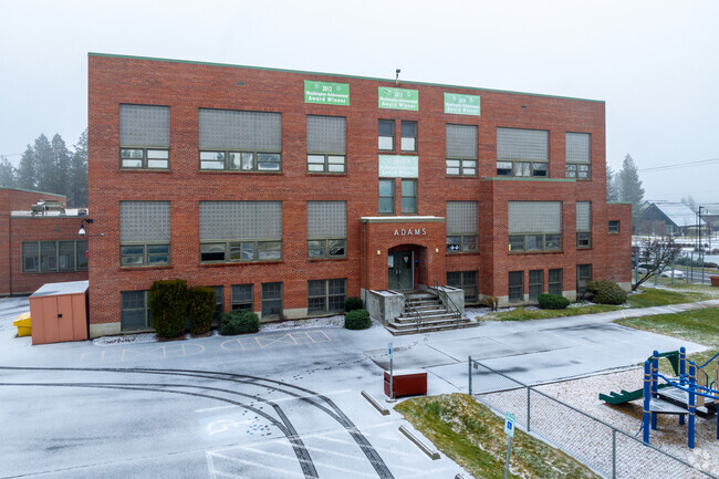 Adams Elementary features  a small brick building for students.