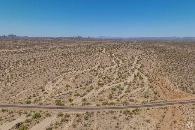 The expansive, remote landscape of Whispering Ranch showcases scattered residences and extensive dirt roads, highlighting the area's appeal for those seeking isolation and natural beauty.