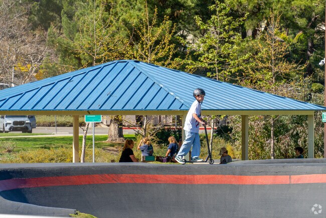 Families enjoy a sunny day under the shade at the playground in Paseo del Sol, Temecula.