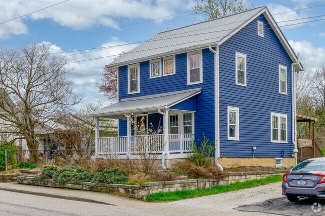 An older, 19th-century two-story home is located in an older area of McDoel Gardens.