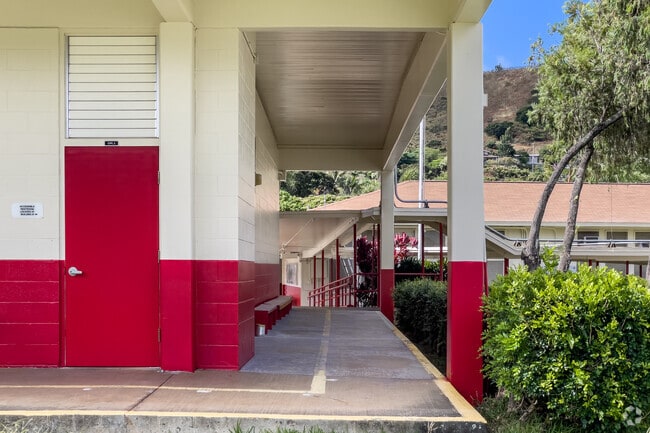 The school's vibrant campus is surrounded by lush greenery and beautiful tropical flowers.